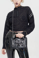 Pull punk femme en laine noire avec épaules tombantes, manches perforées, connexion par sangle, col à fermeture éclair, manches longues et coupe ample